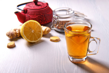 Mug of tea with lemon and ginger, on a white background, side view