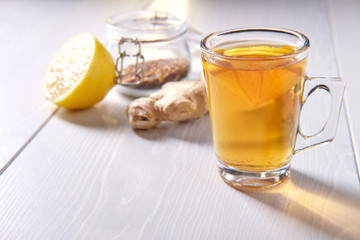 Mug of tea with lemon and ginger, on a white background