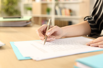Woman hands filling out form working at home