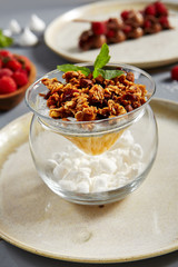 Chia pudding with thai mango and caramelized granola in glass bowl