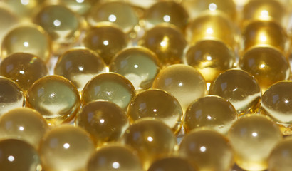 Yellow fish oil in capsules background. Omega3 vitamins close-up. Capsules fish oil macro. Vitamins for health.