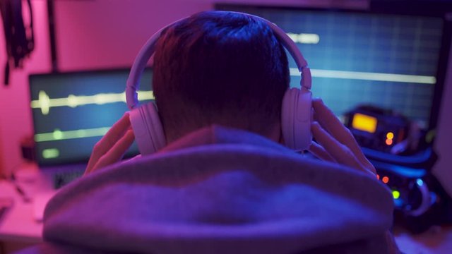 Person takes off hoodie - has headphones - recoding sound and voice conversations