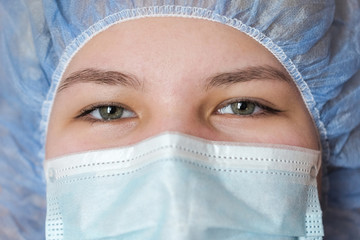 Close-up of the doctor's eyes. Medical employees in a protective mask and cap