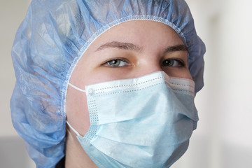 Close-up of the doctor's eyes. Medical employees in a protective mask and cap