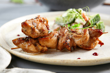 Chicken hip barbecue with homemade fresh vegetable salad in beige plate