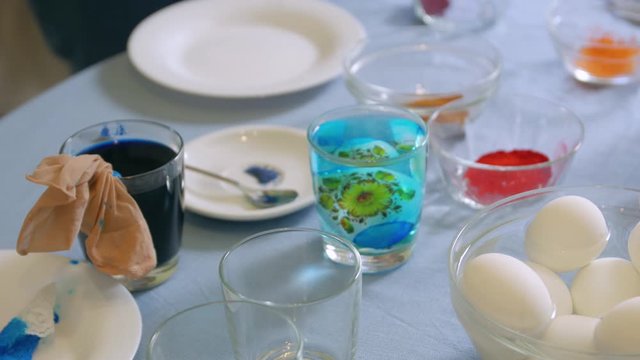 Woman paints eggs blue color sticker unrecognizable female hands closeup Easter holiday caucasian white