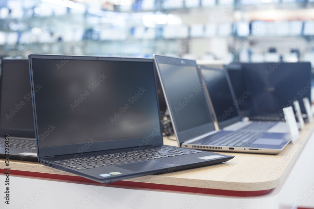 Wall mural laptops on the table in the electronics store.