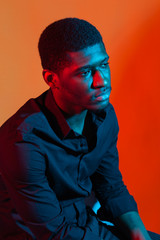 Dark neon portrait of young man wearing in shirt. Red and blue light. Technology