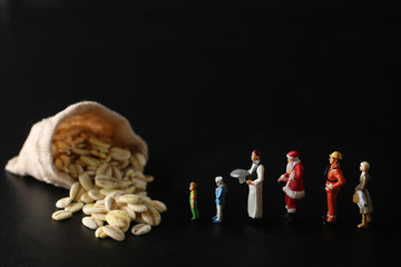 食糧危機とお金と人間のミニチュア人形を使ったジオラマ