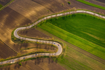 Curvy road and empty agricultural fields in spring. 