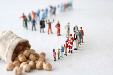 食糧危機とお金と人間のミニチュア人形を使ったジオラマ