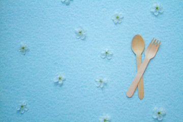 Eco-friendly disposable kitchenware and apple flowers on a blue background. The concept of zero...
