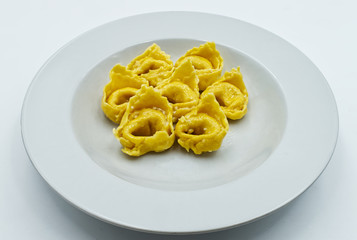 Homemade Tortellini with butter and sage sauce isolated on white. Traditional italian pasta. 