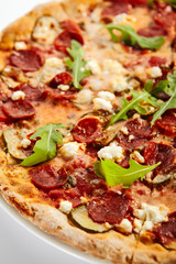 Pepperoni pizza slices with arugula on plate
