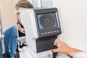Medicine, health, ophthalmology concept - patient checks her vision by an ophthalmologist.