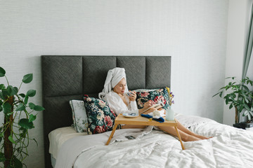 Beautiful girl with a towel on her head works at home. Work at the computer at home, work as a...