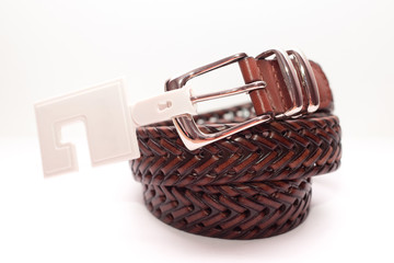 Close-up classic men's brown leather belt on a white background. Wicker belt.