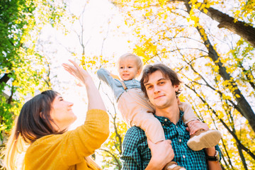 Low angle portrait of happy family together, father, mother and little son giving high five