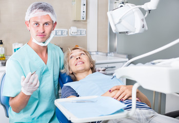 Dentist examining and performing treatment to woman