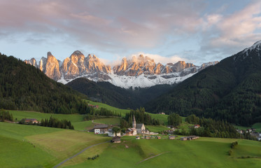 Small Italian mountain town of St. Magdalena in Val di Funes at sunset