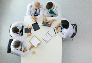 Medical team sitting and discussing at table, top view