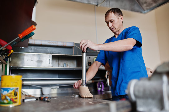 Prosthetist man making prosthetic leg while working in laboratory.