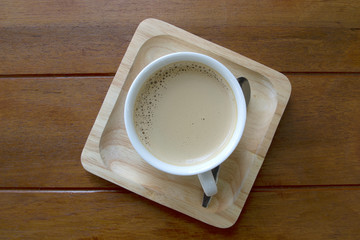 Cup of coffee on wooden table, top view