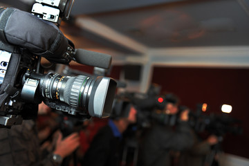 Videocamera and journalists at press conference