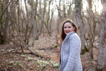 Pregnant beautiful happy woman walks in the autumn forest, she breathes the clean forest air, which is good for her health