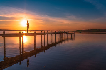 Fototapeta na wymiar Frau genießt den Sonnenuntergang am Ammersee