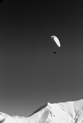 Paraglider in high snowy mountains at sun winter day