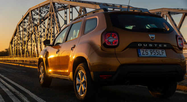 Dacia Duster SUV standing on a steel truss bridge at sunset