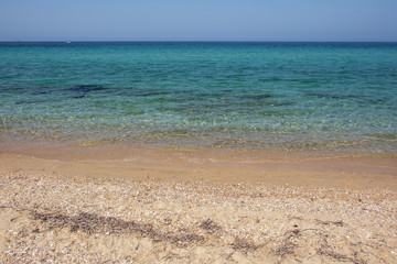 Fototapeta na wymiar The endless expanse of the sea and sandy beach. Transparent waves, Halkidiki, Greece.