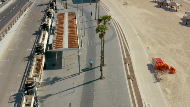 Wolt Delivery cyclist on empty Tel Aviv boardwalk, Israel coronavirus lockdown, aerial