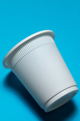 disposable glass of corn starch on a blue background. biodegradable dishes. eco friendly. isolate. replacement plastic.