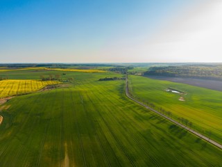 Aerial view of rural area with blue sky and green agricultural fields in spring in Germany
