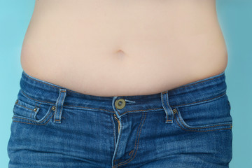 Naklejka premium Woman measures a fat belly. Healthy lifestyles concept. Background to obesity