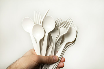 disposable tableware from environmentally friendly materials in a hand on a white background....