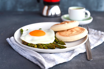 Healthy breakfast. Fried eggs, asparagus, bread and aromatic coffee on a gray background. Free place for text. Soft focus