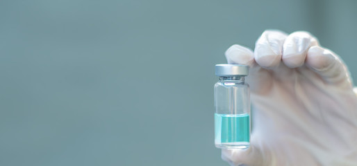 Biology and science. Scientist holding a vaccine vial. Global alert. Vaccination. Covid-19. Coronavirus. Research.