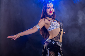 Fototapeta na wymiar Portrait of a woman in oriental costume performing belly dance. Tribal fusion dance concept.