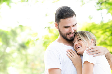 Happy young caucasian couple embracing together with passionate love in public park,Couple in love hugging and having romantic tender moments in the summer vacation.Lifestyle loving couple at nature.