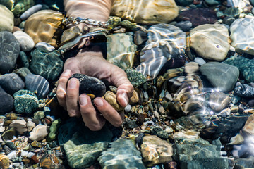 female hands holding pebbles