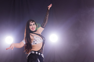 Young woman dancing in Tribal Fusion style. Belly dance on the stage. Copy space.