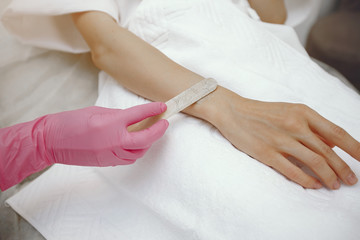 Hair removal. Gel for laser. Woman in a pink gloves.