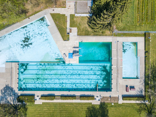 Aerial view of abandoned swimming pool with dirty water.