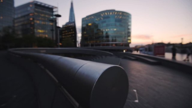  Focus Image Of Stainless Steel Railings At Road Side With Illuminated Buildings In London, England At The Background.- close up panning shot