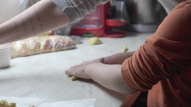 Footage of caucasian mother and son, preparing traditional greek easter cookies for Easter,during coronavirus lockdown, Slow motion