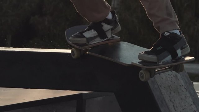 Closed travelling shot of a skateboarder doing a BS Smith in a ledge at the goldenhour in a skatepark in Barcelona