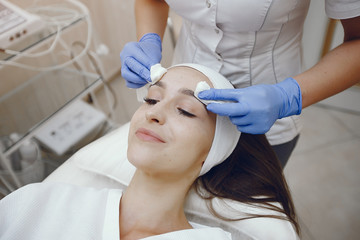 Naklejka premium Cosmetologist treats client's skin. Woman with cosmetologist. Lady in a beauty studio.